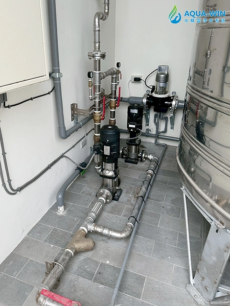 Complete installation view of whole-house backwash filtration system next to water storage tank